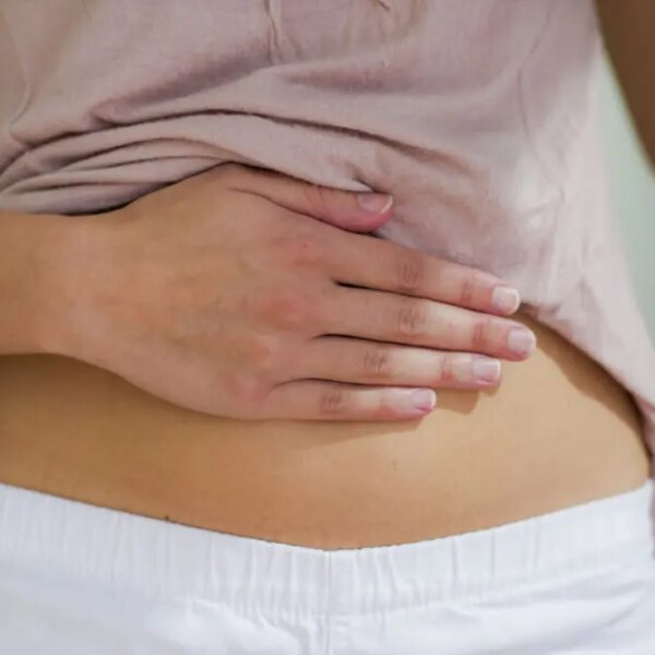 Close up of woman's hand placed on her stomach.