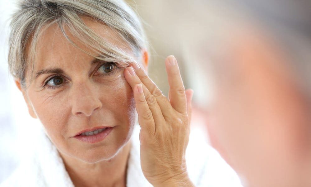 Mature woman looking at her reflection in the mirror.