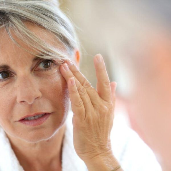 Mature woman looking at her reflection in the mirror.