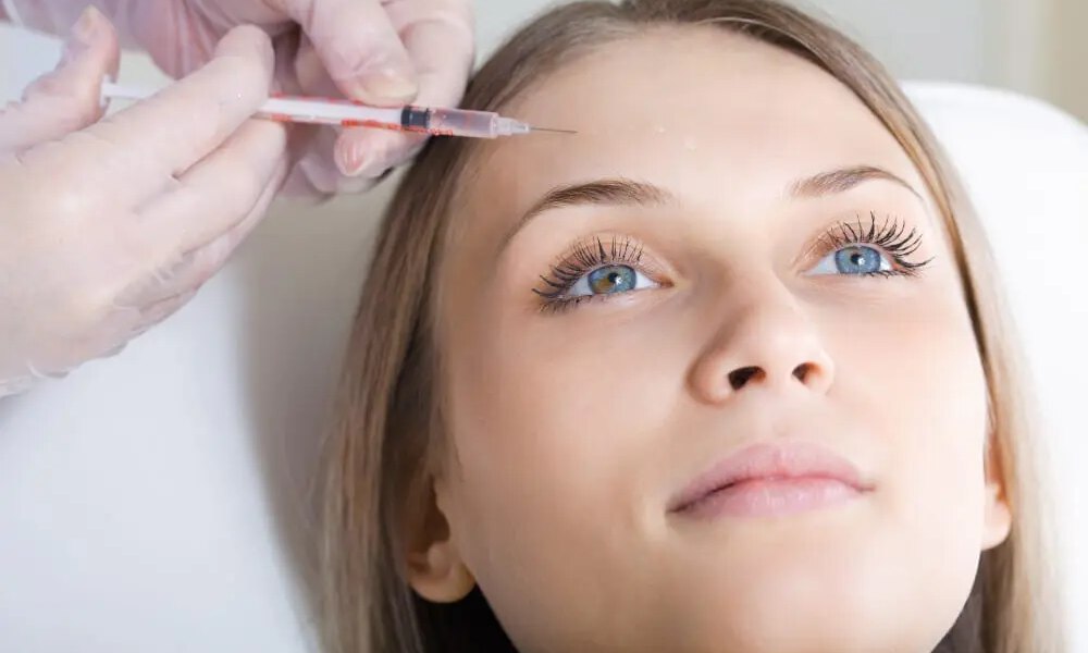 Woman gettting Botox injections in her forehead.