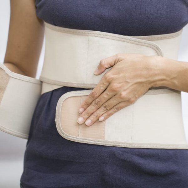 woman's wrapping her midsection with a compression garment.