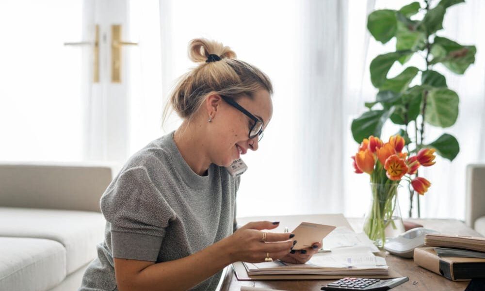 Woman talking on the phone in her home office preparing for her breast augmentation.