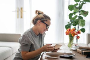 Woman talking on the phone in her home office preparing for her breast augmentation.