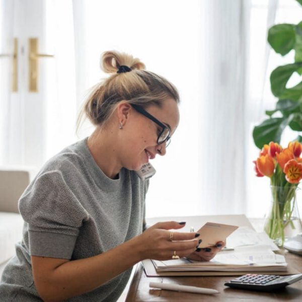 Woman talking on the phone in her home office preparing for her breast augmentation.