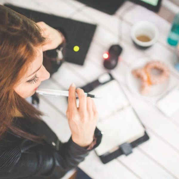 Overhead view of woman with red hair writing out a schedule