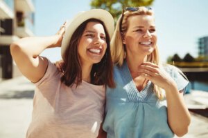 Two female friends enjoying a day outside together discussing breast augmentation.